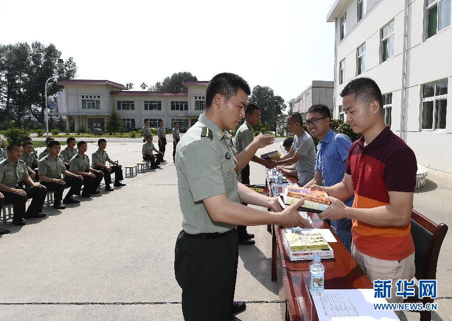 8月1日,强海飞(右一)等三名老兵在给部队捐赠书籍.