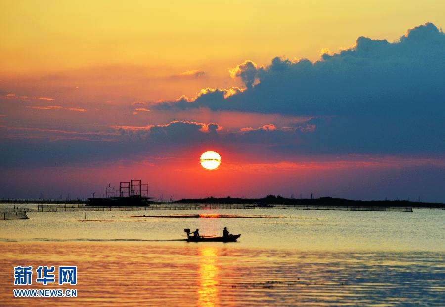 9月8日,二十四节气的白露,在江苏洪泽湖,一艘小船在夕阳余晖映照的