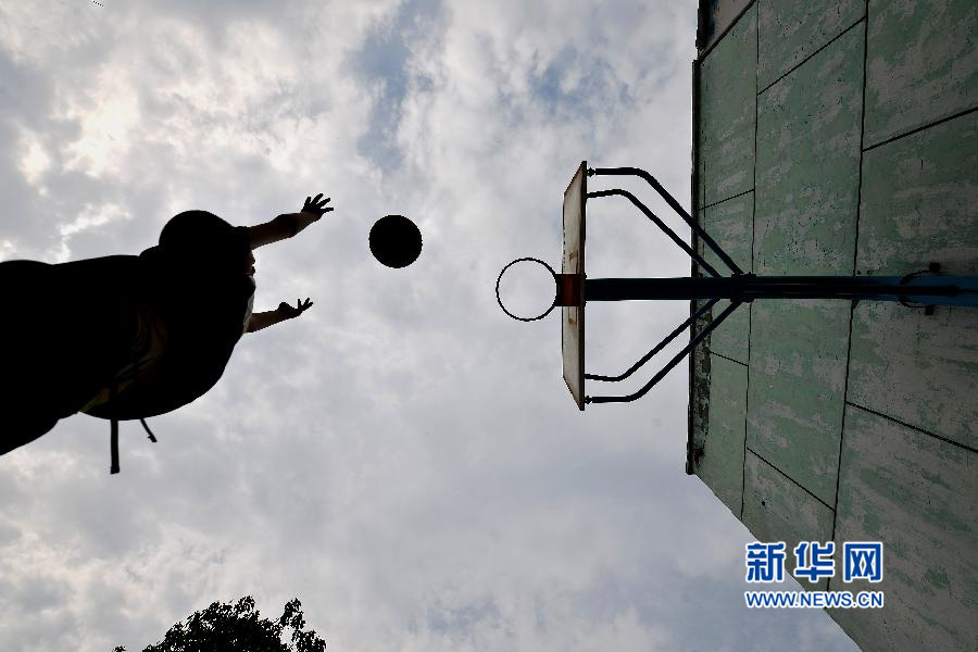 5月30日,在山西临汾红丝带学校,一个孩子在练习投篮.